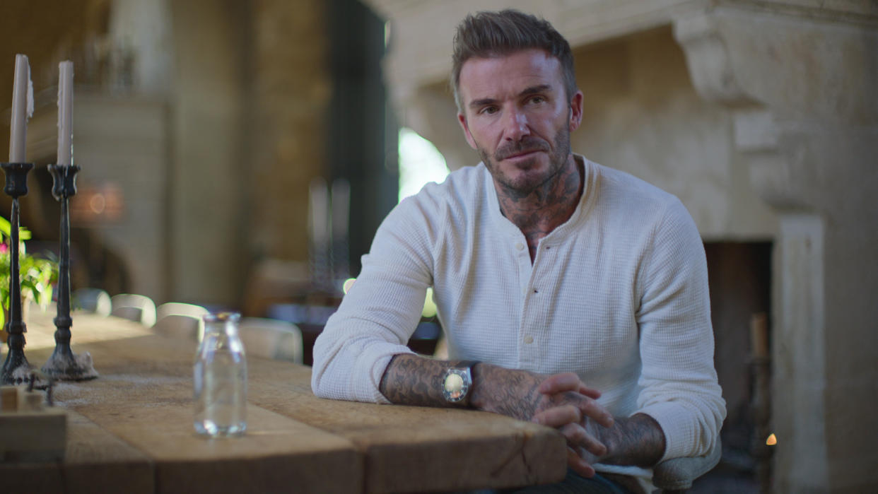  David Beckham sits stony faced at a table in his Netflix docuseries. 