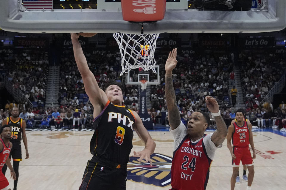 Phoenix Suns guard Grayson Allen (8) goes to the basket against New Orleans Pelicans guard Jordan Hawkins (24) in the first half of an NBA basketball game in New Orleans, Monday, April 1, 2024. (AP Photo/Gerald Herbert)