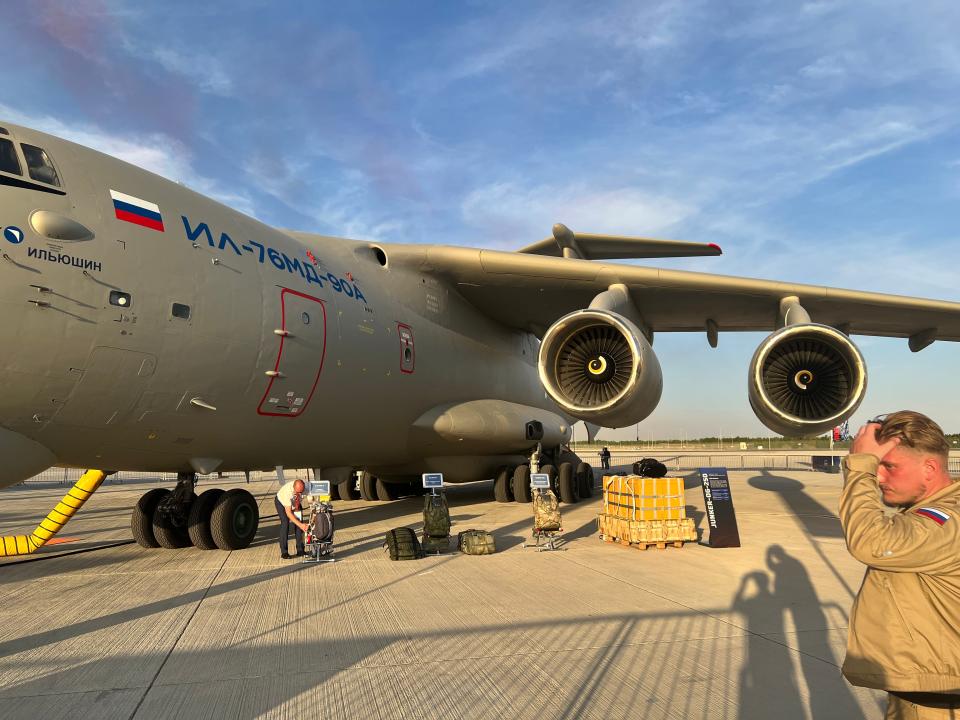 A three-quarters view of the Ilyushin Il-76 focused on the engines with a Russian soldier in the foreground