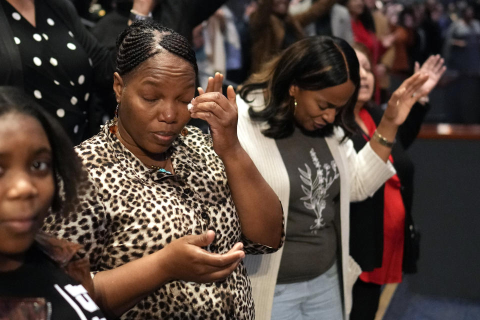 A woman wipes away a tear during a service at Lakewood Church, Sunday, Feb. 18, 2024, in Houston. Pastor Joel Osteen welcomed worshippers back to Lakewood Church for the first time since a woman with an AR-style opened fire in between services at his Texas megachurch last Sunday. (AP Photo/David J. Phillip)