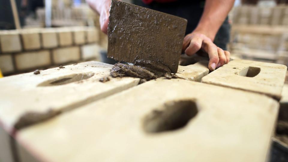 Ein Auszubildender zum Maurer arbeitet im Ausbildungszentrum Butzweilerhof an einer Mauer.