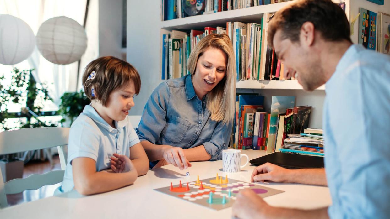 Family playing board game at home.