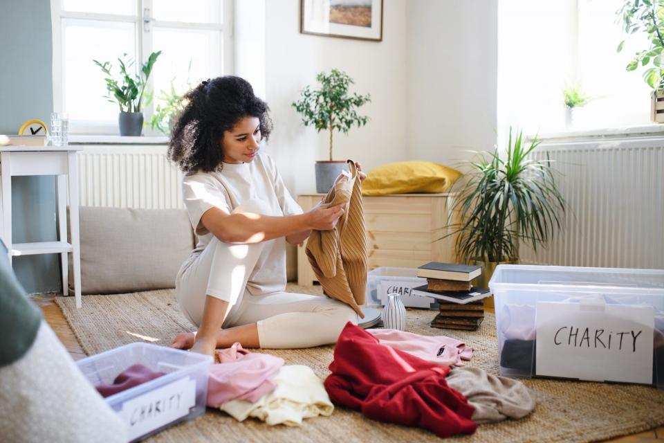 Questions to Ask When Decluttering, woman decluttering clothes