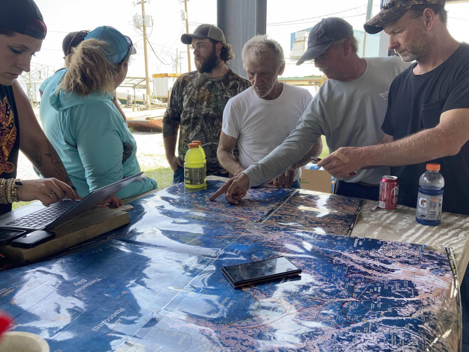 Volunteers gather around a map of the Louisiana coast on Thursday, April 30, 2021, in Cocodrie, La., as they search for survivors of the Seacor Power, a lift boat that capsized off the coast on April 13. (AP Photo/Rebecca Santana)