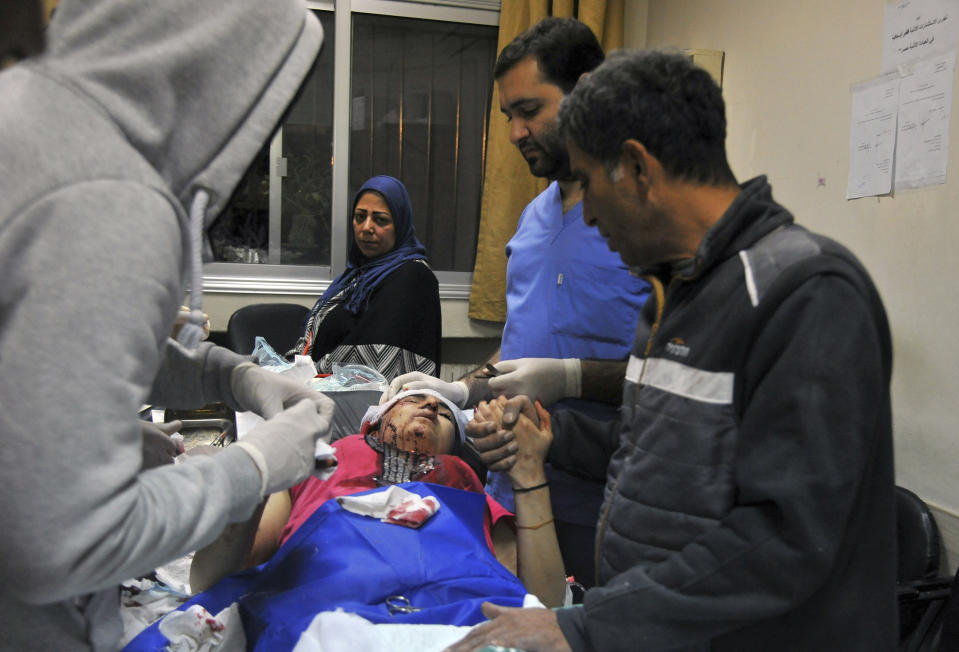 In this photo released by the Syrian official news agency SANA, a paramedic treats an injured woman wounded by Israeli missile strikes at a hospital in Damascus, Syria, Wednesday, Nov. 20, 2019. The Israeli military on Wednesday said it struck dozens of Iranian targets in Syria, carrying out a "wide-scale" strike in response to rocket fire on the Israeli-controlled Golan Heights the day before. (SANA via AP)