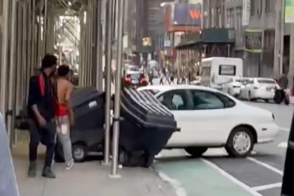 The driver of a white sedan mounted the sidewalk on West 39th Street in Midtown Manhattan on Monday, video shows. WhatIsNewYork/Instagram