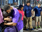 Shoshana Boyd (L) and Olympic sprinter Tyson Gay embrace during a candlelight vigil at Lafayette High School for their daughter Trinity Gay, who died in an exchange of gunfire early Sunday morning, in Lexington, Kentucky October 17, 2016. REUTERS/Bryan Woolston