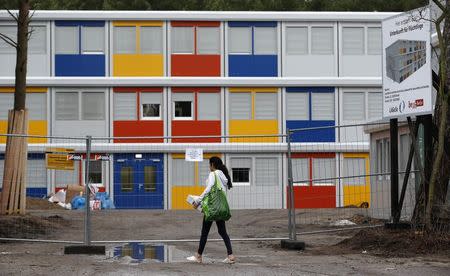 A resident enters a new refugee centre for housing asylum seekers in the Koepenick district of Berlin January 2, 2015. Six new container camps for refugees are to be built in the capital. REUTERS/Fabrizio Bensch