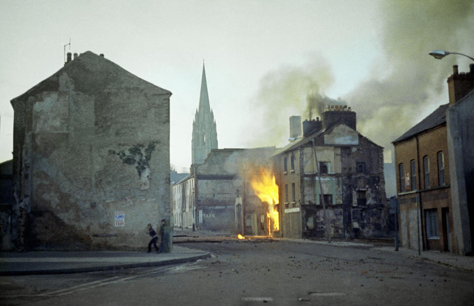 FILE - In this February 1972 file photo, a building burns in the bogside district of Londonderry, Northern Ireland, in the aftermath of Bloody Sunday, one of the the most notorious events of “The Troubles.” Time has not completely healed the hatred, distrust and fear of those caught up in the decades-long conflict. (AP Photo/Michel Laurent, File)