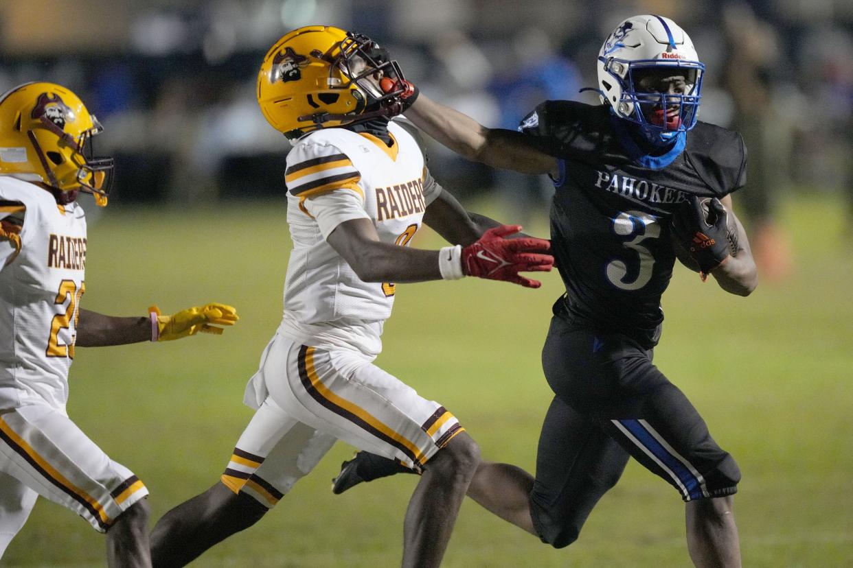Rashon Brown Jr. (3) of Pahokee stiff-arms Tavarion James (8) of Glades Central during the second half of a high school football game at Pahokee High School in Pahokee, Florida, Nov. 3, 2023.