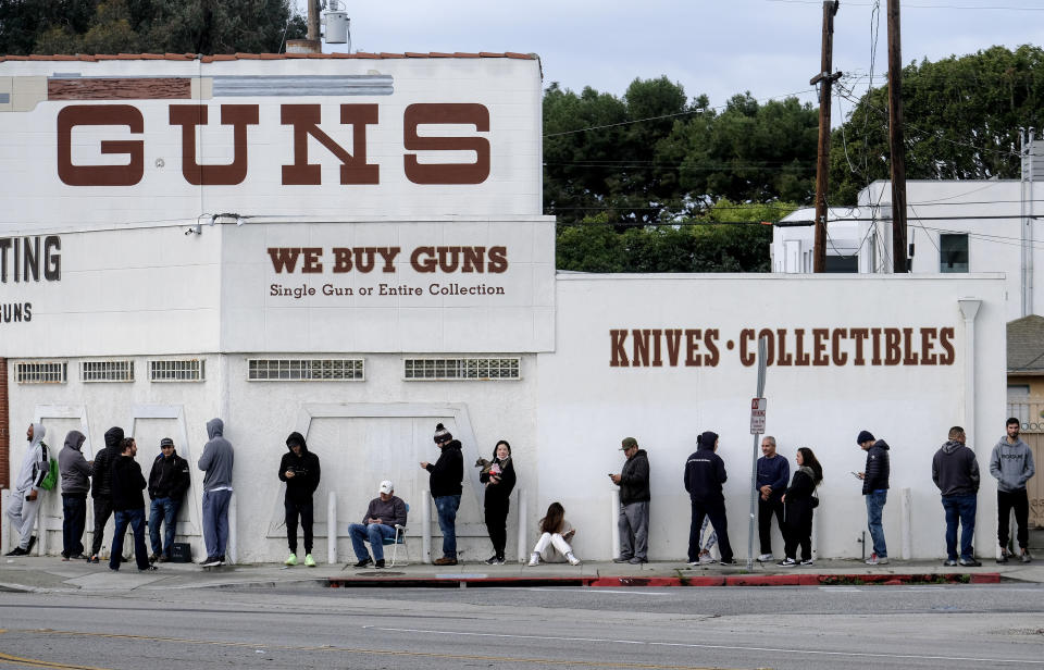 FILE - In this March 15, 2020, file photo, people wait in a line to enter a gun store in Culver City, Calif. The coronavirus pandemic has much of the world contemplating an existential question amid a growing number of stay-at-home orders, with only "essential" service providers allowed to go to their jobs. As U.S. states enact sweeping stay-at-home orders, there is lots of agreement on what's essential, but some have their own notions. A few are eyebrow raisers. Among them are guns, golf and cannabis. Most lists, being compiled by governors and others, capture the basics of what's essential. (AP Photo/Ringo H.W. Chiu, File)