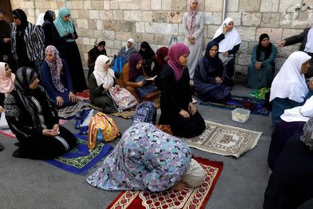 Palestinian women pray outside the compound known to Muslims as Noble Sanctuary and to Jews as Temple Mount at morning after Israel removed the new security measures there, in Jerusalem's Old City July 25, 2017. REUTERS/Ronen Zvulun