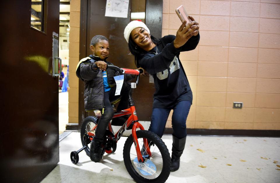 Deanna Brown-Thomas, a daughter of the late singing legend James Brown, takes a selfie with Jashawn McKie, then 4, after he gets a new bike at the 29th annual James Brown Toy Giveaway in December 2019 in Augusta, Ga.