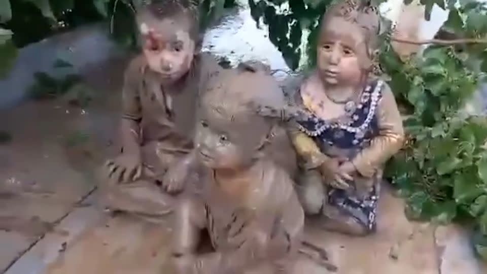 Three children, aged 3, 5 and 6, on the roof of a mosque in Baghlan province, Afghanistan after being rescued from flooding and mud torrents. - Afghanistan Journalist Group