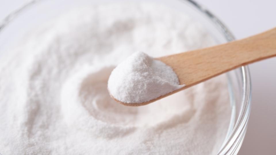 A bowl of aspartame, an artificial sweetener, with a wooden spoon