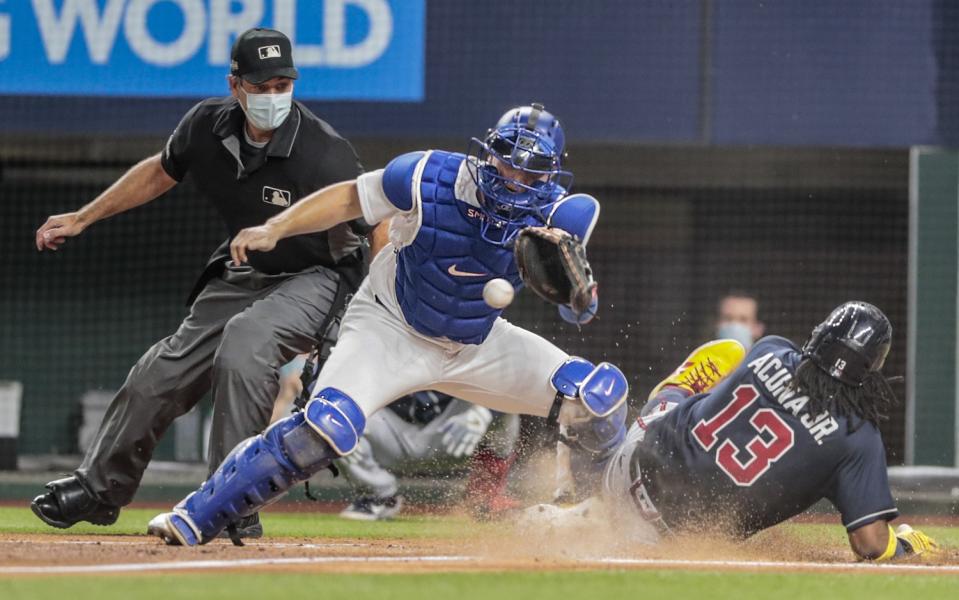 Ronald Acuna Jr. slides into home, beating the throw to Dodgers catcher Will Smith.