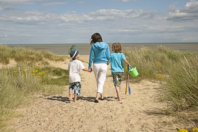 Mother and sons walking on beach