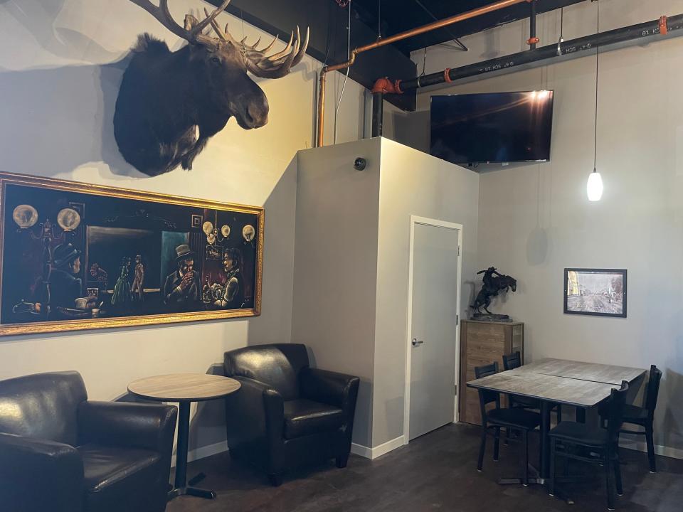 A painting from the historical and long-closed Canopy Restaurant hangs under a moose head at the new The Canopy Lounge in downtown Brighton Thursday, June 9, 2022.