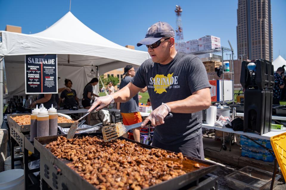 Yor Choun grills pork shoulder at the Sarinade food stand during the 20th annual CelebrAsian festival in Western Gateway Park, Friday, May 26, 2023. 