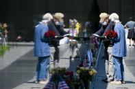 Masked visitors to the Vietnam Memorial pay respects in Washington