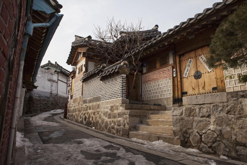 A narrow alleyway lined with preserved, historic homes in Bokchon Hanok Village; Seoul, Korea.