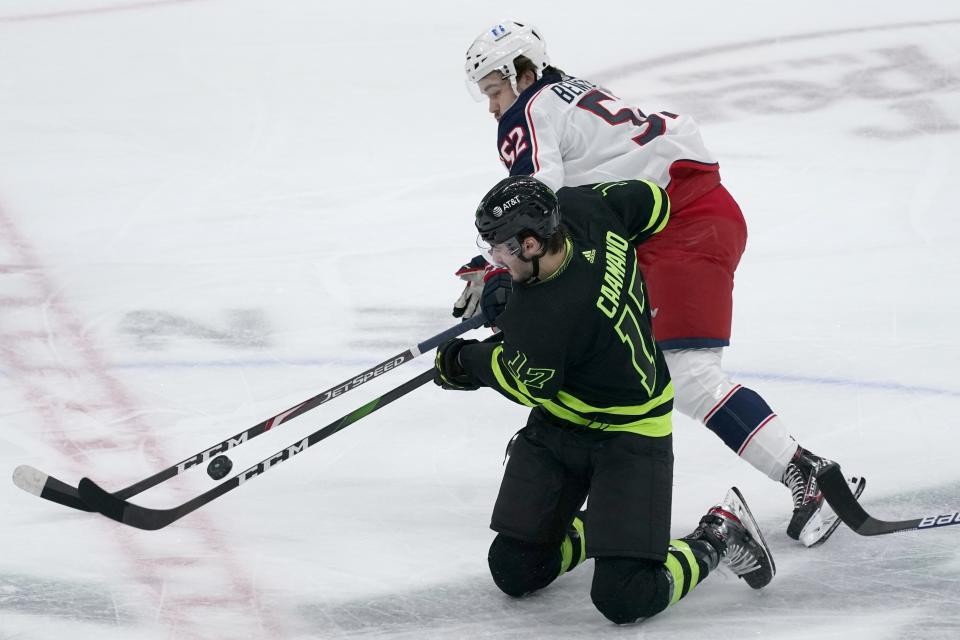 Dallas Stars right wing Nick Caamano (17) and Columbus Blue Jackets center Emil Bemstrom (52) compete for control of the puck in the first period of an NHL hockey game in Dallas, Saturday, March 6, 2021. (AP Photo/Tony Gutierrez)