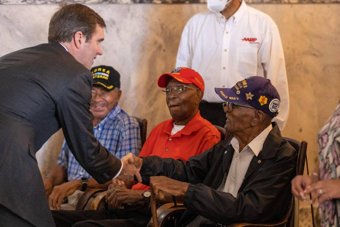 Gov. Andy Beshear shakes the hand of Kentucky veteran Albert West, 99, who lives near Paris, KY’s city dump along with veterans William Woodford, left, 88, and David Downey, center, 96. Beshear announced a $2 million grant on September 12, 2022 to relocate the city’s dump away from residential areas.