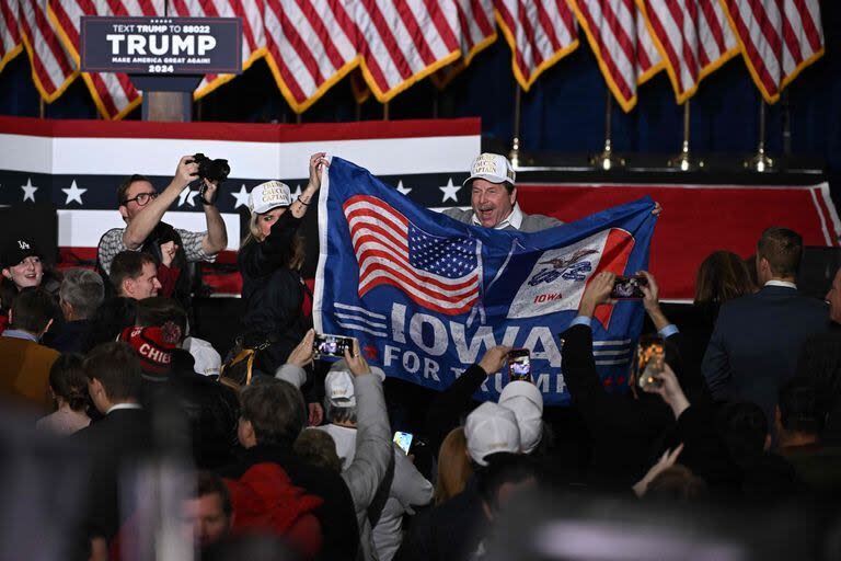 Los partidarios del ex presidente estadounidense y aspirante presidencial republicano Donald Trump celebran en una fiesta de observación durante los caucus presidenciales republicanos de Iowa de 2024 en Des Moines (Jim WATSON / AFP)
