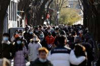 People wearing face masks following the coronavirus disease (COVID-19) outbreak walk along Nanluoguxiang alley