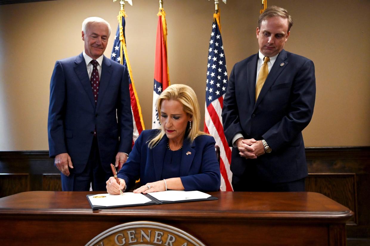 Governor Asa Hutchinson, left, and Matthew Shepherd, Speaker of the House, right, watch as Leslie Rutledge, Arkansas Attorney General, signs the official certification to prohibit abortions in Arkansas during a press conference at the Attorney General's office in Little Rock, Ark., Friday, June 24, 2022. 