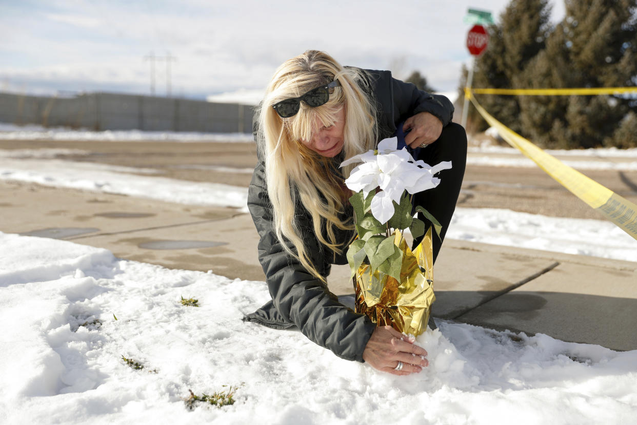 Sharon Huntsman, a member of The Church of Jesus Christ of Latter-day Saints from Cedar City, Utah, leaves flowers outside a home where eight family members were found dead in Enoch, Utah, Thursday, Jan. 5, 2023. (Ben B. Braun/The Deseret News via AP)