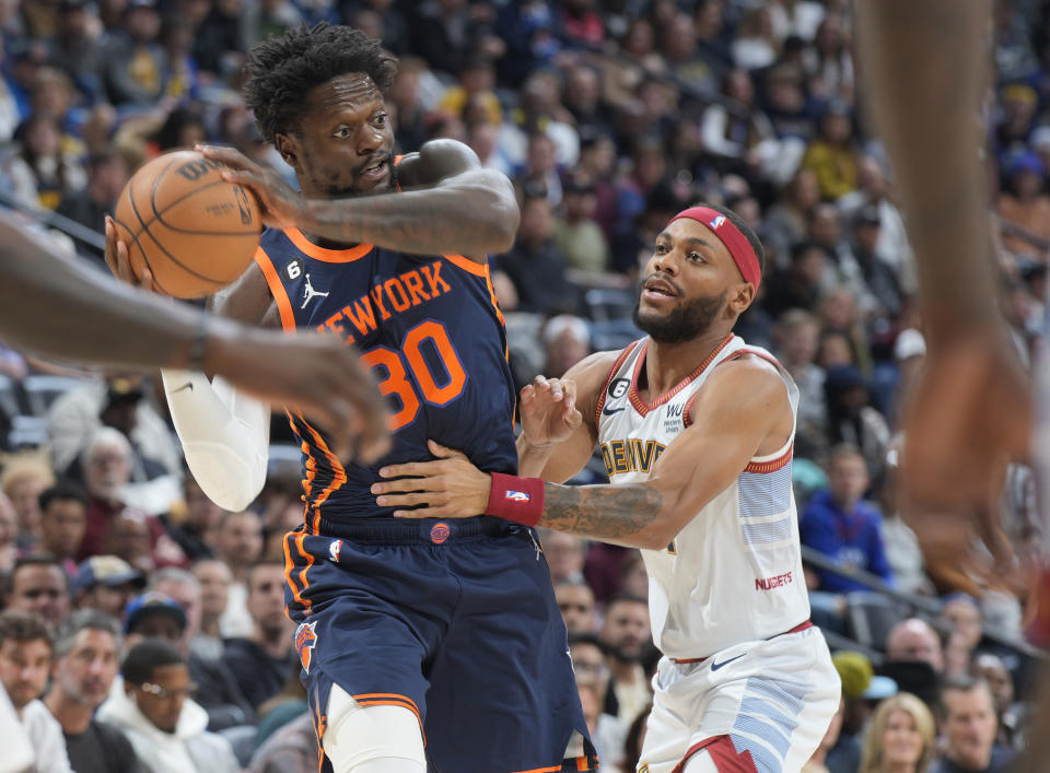 New York Knicks forward Julius Randle, left, looks to pass the ball as Denver Nuggets forward Bruce Brown defends in the first half of an NBA basketball game Wednesday, Nov. 16, 2022, in Denver. (AP Photo/David Zalubowski)