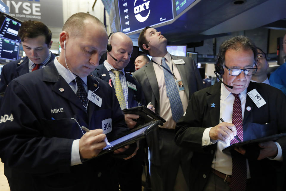 Traders gather at the post that handles Oaktree Capital Group on the floor of the New York Stock Exchange, Wednesday, March 13, 2019. U.S. stocks opened broadly higher on Wall Street Wednesday, powered by technology and health care companies, as the market pushes for its third straight day of gains. (AP Photo/Richard Drew)