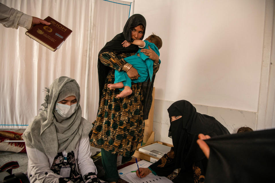 Lahorah, 30, with her year-old son, Safiullah, at a mobile clinic set up by UNICEF in the remote village of Alisha, in Wardak Province, Afghanistan, on June 11. The Taliban's rulers have reinstituted an emirate governed by a strict interpretation of Islamic law and issued a flood of edicts curtailing women's rights, institutionalizing patriarchal customs, restricting journalists and effectively erasing many vestiges of an American-led occupation and nation-building effort.<span class="copyright">Kiana Hayeri—The New York Times/Redux</span>