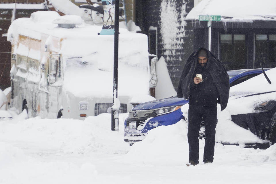 A man covers his head with a jacket during a storm, Sunday, March 3, 2024, in Truckee, Calif. (AP Photo/Brooke Hess-Homeier)