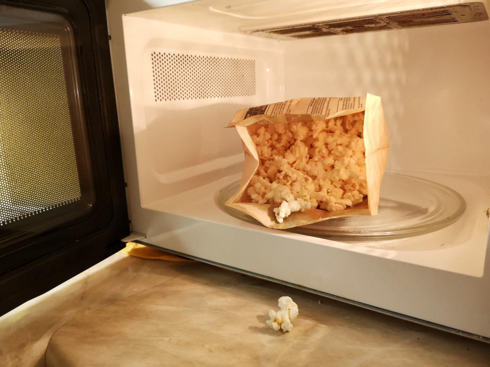 A bag of freshly-popped popcorn in a microwave