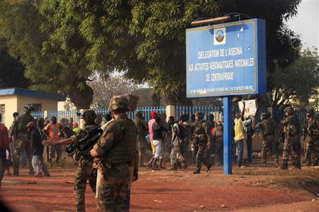 French military personnel try to control supporters who are asking them to disarm fighting gangs, near the airport in Bangui December 23, 2013. REUTERS/Andreea Campeanu