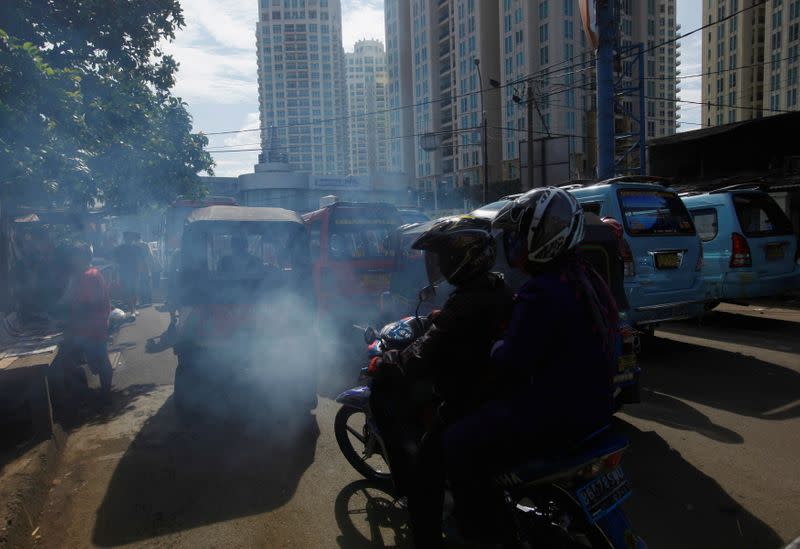 FILE PHOTO: Exhaust fumes are seen coming from a vehicle stopped at traffic lights in Jakarta