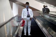 Un hombre con mascarilla sube por una escalera mecánica en la Estación de Ferrocarril Hongqiao de Shangai el último día de la fiebre por el viaje del Festival de Primavera, mientras el país es golpeado por un brote del novedoso coronavirus, en Shangai, China, el 18 de febrero de 2020