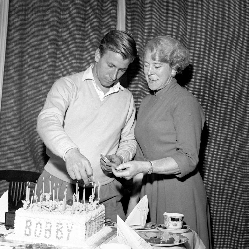 Aided by his mother, Betty, Charlton lights the candles on his 21st birthday cake at his home at Ashington (PA)