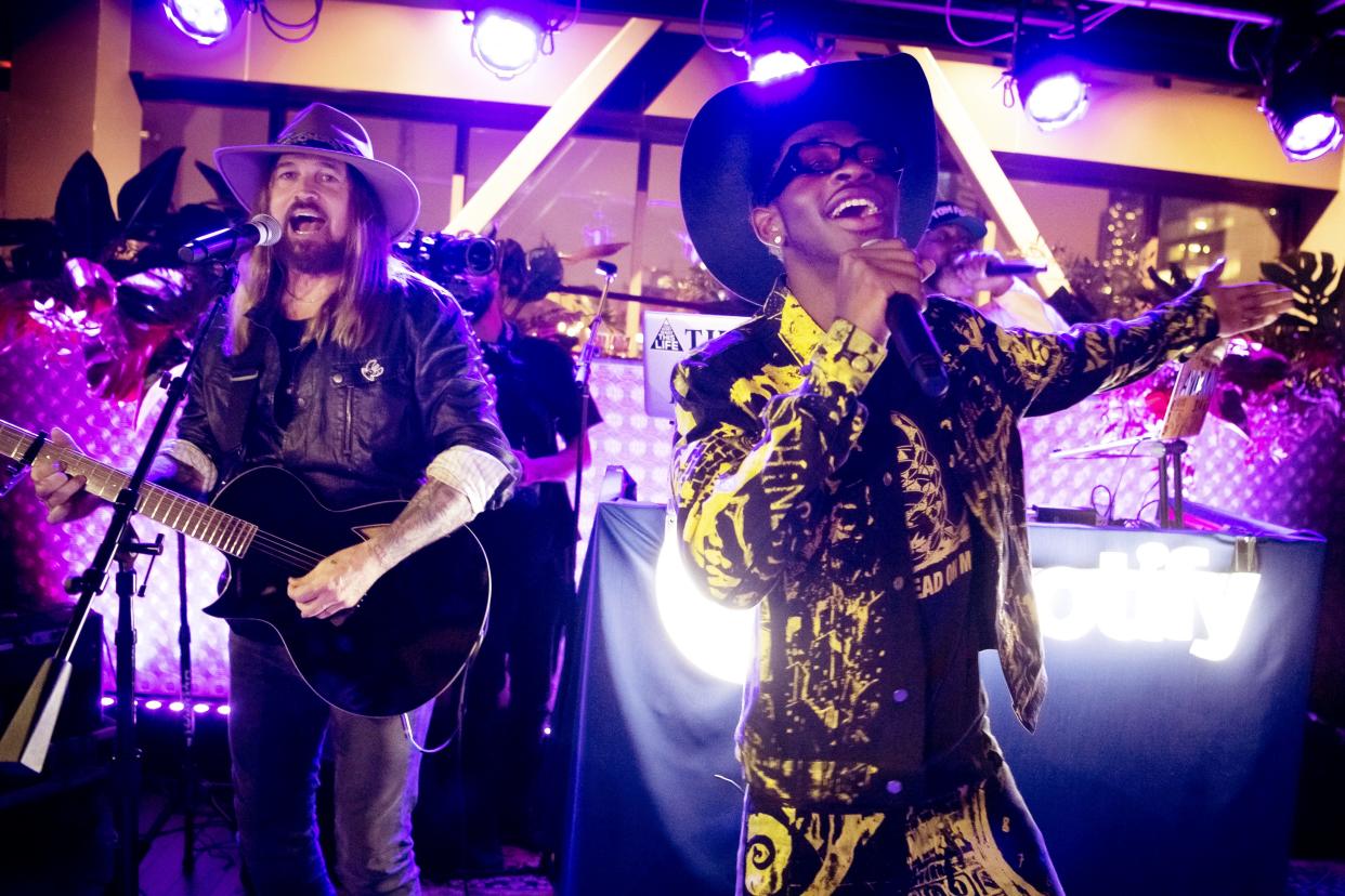 Lil Nas X, right, and Billy Ray Cyrus perform the huge hit, "Old Town Road," at the Spotify House at Ole Red in Nashville on June 7, 2019.