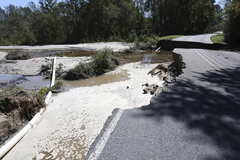 FILE - A portion of Wood Peck Road near Bradshaw's Garage outside of Goldsboro, N.C., washed away due to flood waters caused by Hurricane Matthew in 2016. Nearly six years after extreme rainfall and flooding from Hurricane Matthew damaged many North Carolina homes, some homeowners are still left waiting on repairs. A new bipartisan General Assembly committee tasked with investigating the delays holds its first meeting Wednesday, Sept. 14, 2022, on the four-year anniversary of when Hurricane Florence made landfall in North Carolina. (Casey Mozingo/The Goldsboro News-Argus via AP, File)