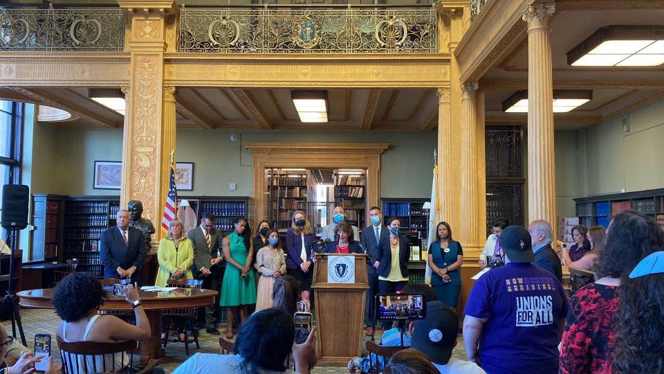 State lawmakers celebrate the override of Gov. Charlie Baker's veto of the of the Work and Family Mobility Act in June.