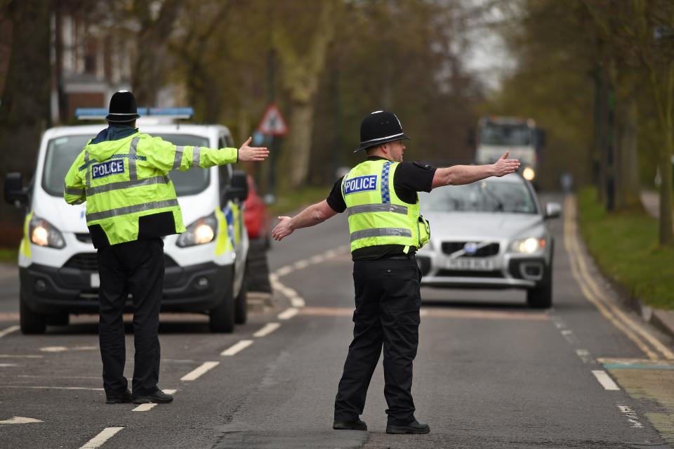 Police officers from North Yorkshire Police stop motorists in cars to check that their travel is "essential", in line with the British Government's Covid-19 advice to "Stay at Home", in York, northern England on March 30, 2020, as life in Britain continues during the nationwide lockdown to combat the novel coronavirus pandemic. - Life in locked-down Britain may not return to normal for six months or longer as it battles the coronavirus outbreak, a top health official warned on Sunday, as the death toll reached passed 1,200. (Photo by Oli SCARFF / AFP) (Photo by OLI SCARFF/AFP via Getty Images)