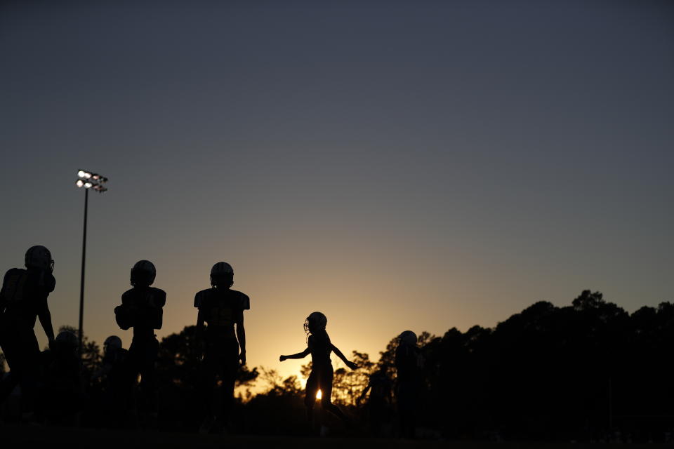 FILE - High school football players warm up before a game on Oct. 27, 2017, in N.C. Several racist incidents targeting Black people occurred in the 2022 high school football season around the nation. (AP Photo/David Goldman, File)