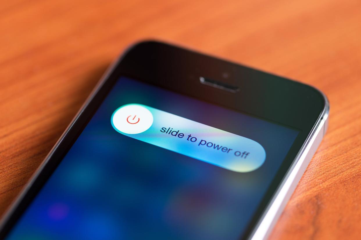 Apple iPhone 5S with slide to power off option on a screen lying on a desk