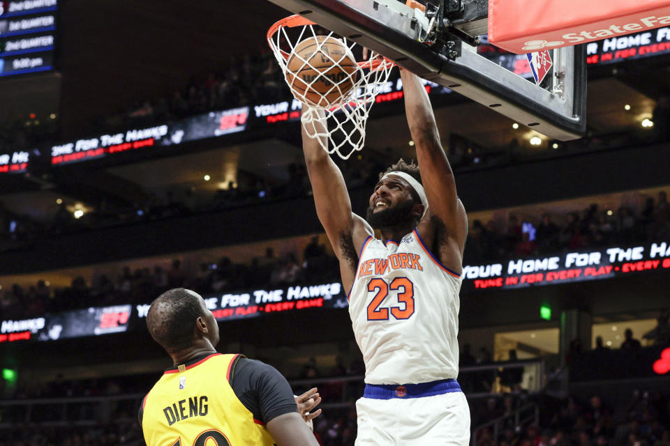 New York Knicks center Mitchell Robinson (23) dunks the ball over Atlanta Hawks center Gorgui Dieng (10) during the second half of an NBA basketball game Saturday, Jan. 15, 2022, in Atlanta. (AP Photo/Butch Dill)