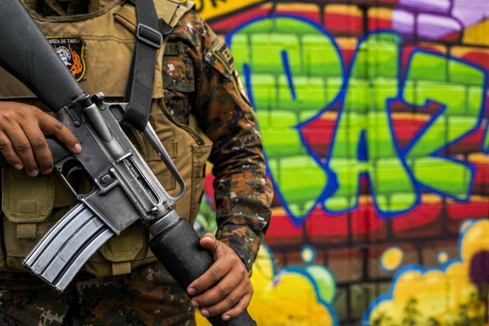 Un militar ante un grafiti que dice 