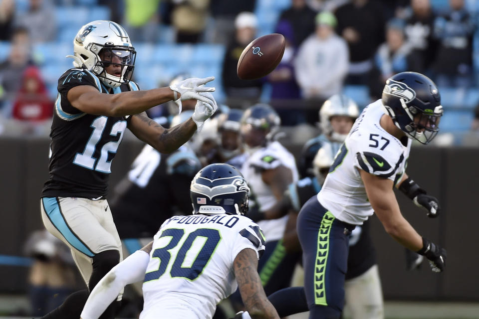 Carolina Panthers wide receiver D.J. Moore (12) reaches for a pass with Seattle Seahawks linebacker Cody Barton (57) and strong safety Bradley McDougald (30) defending during the second half of an NFL football game in Charlotte, N.C., Sunday, Dec. 15, 2019. (AP Photo/Mike McCarn)