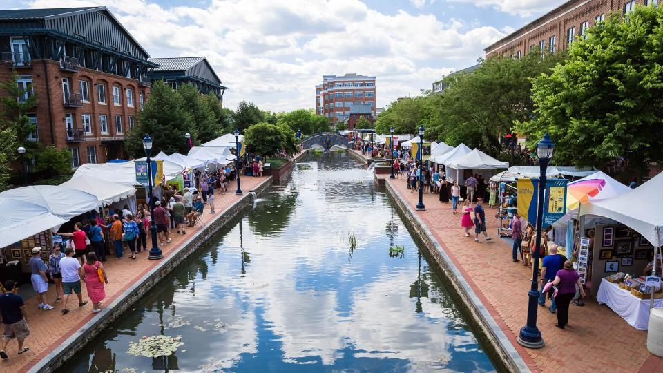 Frederick, MD, USA - June 7, 2014: People gather on the walkway at Frederick Maryland's Linear Creek to celebrate Frederick's annual Festival of the Arts.